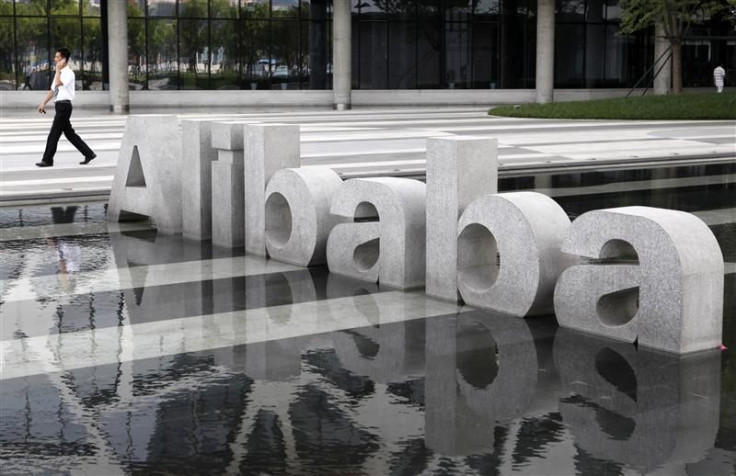 A man walks past a logo of Alibaba (China) Technology Co. Ltd at its headquarters on the outskirts of Hangzhou