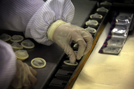 A worker places condoms onto a packaging belt at the Chinese condom manufacturer Safedom's factory in the town of Zhaoyuan.