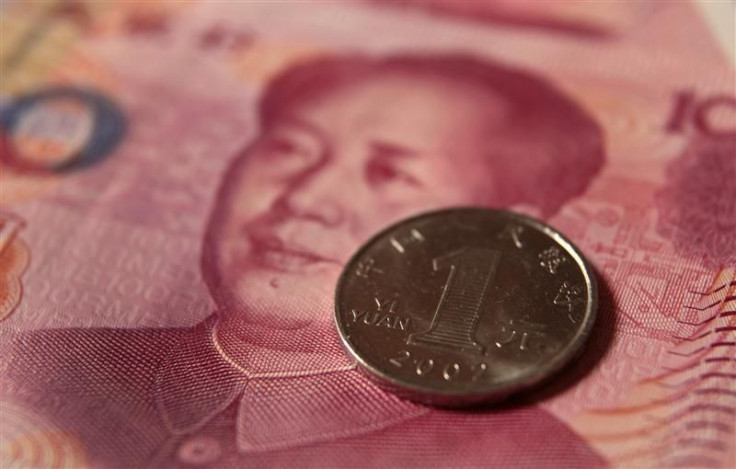 A Chinese one yuan coin and a 100 yuan banknote are seen in this picture illustration taken in Beijing