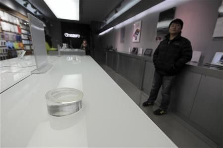 An employee stands next to an empty display desk which was used to put Apple iPads at a dealership in Hefei, Anhui province, February 15, 2012. A Chinese tech firm that claims it still owns the iPad trademark will seek a ban on exports of Apple Inc's
