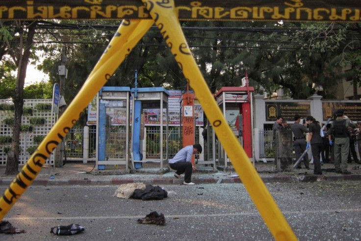 Police and forensic experts investigate the site where a man was injured when a bomb he was carrying exploded, in central Bangkok