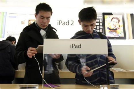 Customers test out Apple iPads in the company&#039;s flagship store in Beijing&#039;s Sanlitun Area