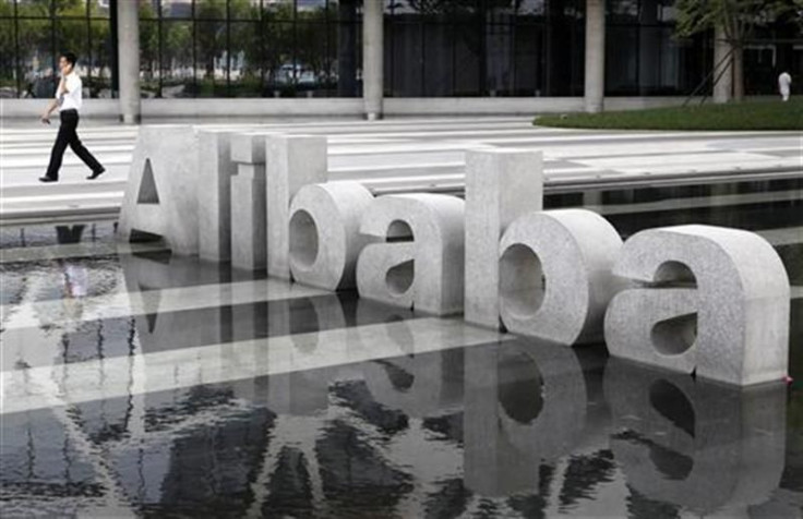 A man walks past a logo of Alibaba (China) Technology Co. Ltd. at its headquarters on the outskirts of Hangzhou.