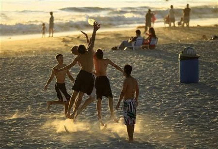 Boys play frisbee in the sand at Moonlight Beach in Encinitas, California