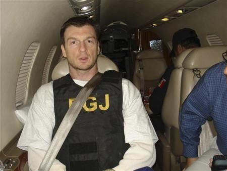 Bruce Beresford-Redman (L) sits inside a plane after his arrival in Cancun February 8, 2012 in this handout picture released by the Attorney General's office (PGR)