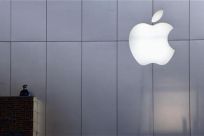 A policeman looks out from a balcony as the crowd is dispersed from the front of an Apple store in Beijing