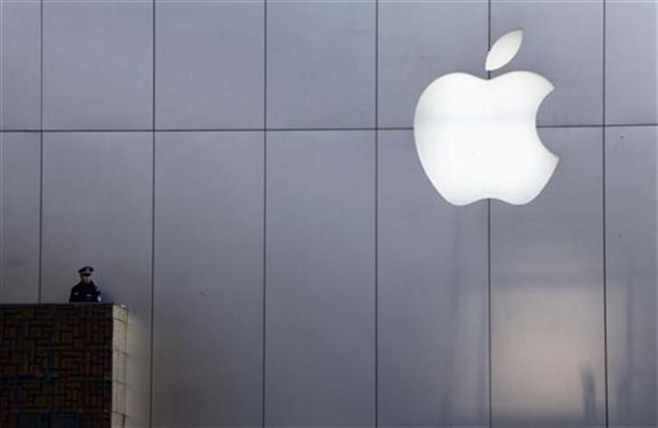 A policeman looks out from a balcony as the crowd is dispersed from the front of an Apple store in Beijing