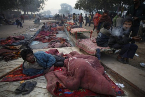 A man wakes up after sleeping out in the open on a chilly morning in New Delhi
