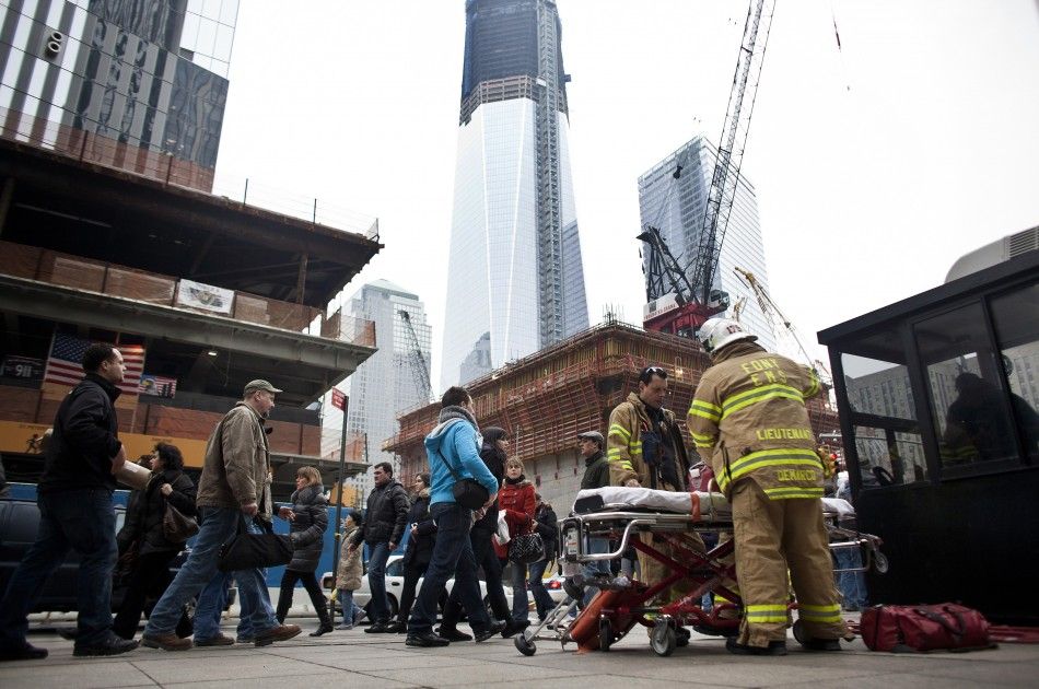 Firefighters stand beside an empty stretcher at the World Trade Center construction site in New York