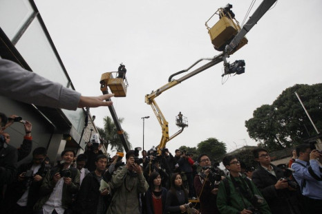 News photographers hoisted up by cranes view the home of Henry Tang in Hong Kong