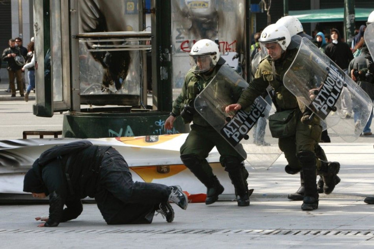 Policemen rush to detain a protester during an anti-austerity rally at central Syntagma square in Athens February 17, 2012.