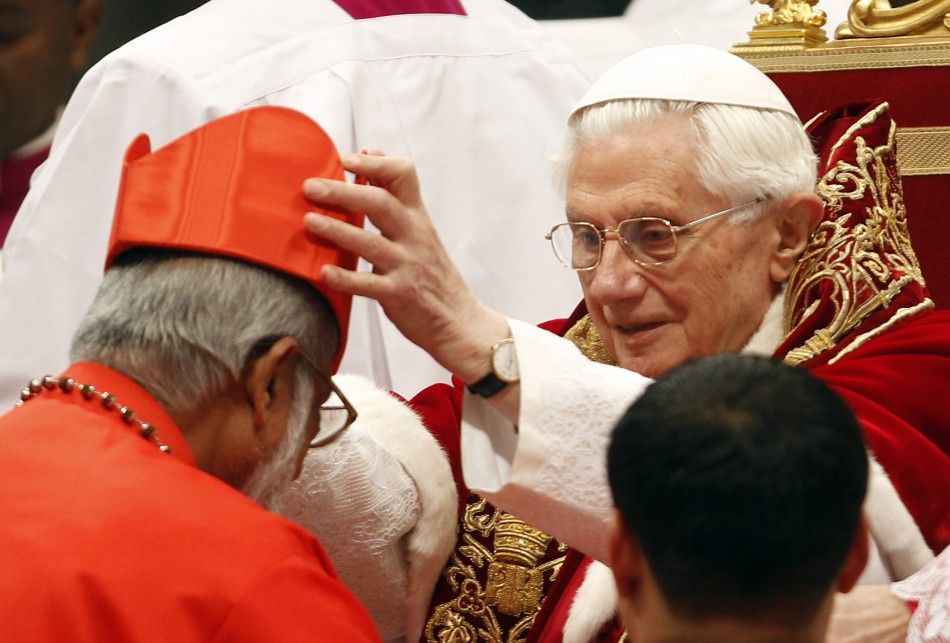 Pope Benedict XVI places a red biretta, a four-cornered hat, on the head of new Cardinal George Alencherry of India
