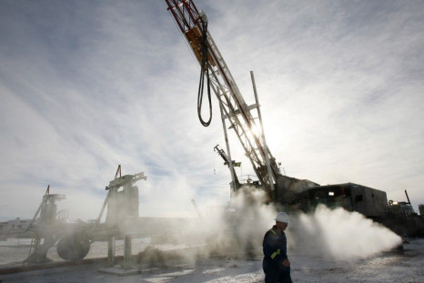 Doug Shea, drill informant for EnCana, walks past an EnCana gas drilling well east of Calgary, Alberta, February 15, 2007.