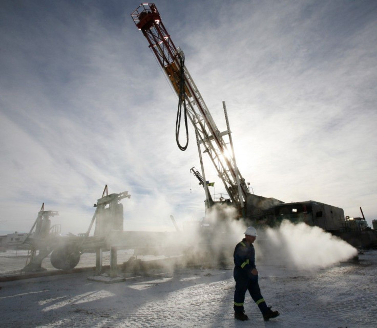 Doug Shea, drill informant for EnCana, walks past an EnCana gas drilling well east of Calgary, Alberta, February 15, 2007.