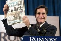 Republican Mitt Romney holds up a Boston newspaper announcing his victory in the Massachusetts Governor's race during his acceptance speech, November 5, 2002 in Boston.