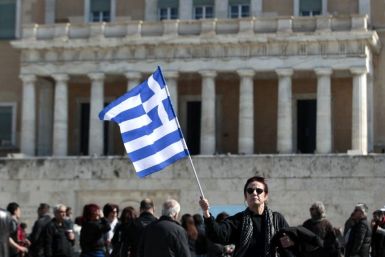 A woman raises a Greek flag during an anti-austerity rally in front of the parliament in Athens February 19, 2012.
