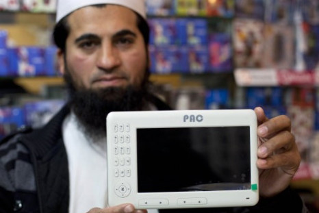 Mohammad Imran holds a Pakistani-made PACPad computer tablet at his electronics store in Rawalpindi, Pakistan.