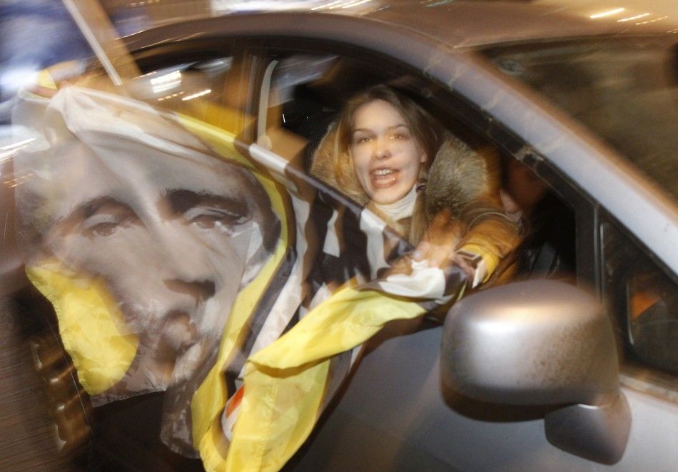 A participant holds a flag with a portrait of Russian Prime Minister Vladimir Putin during a car rally to show support for Putins presidential candidacy in Moscow Feb. 18, 2012. Russia will go to the polls for a presidential election on March 4.