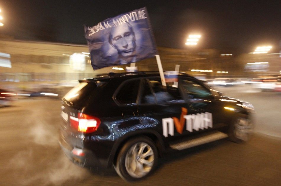 A car drives with a flag showing a portrait of Russian Prime Minister Vladimir Putin during a car rally to show support for Putins presidential candidacy in Moscow Feb. 18, 2012. Russia will go to the polls for a presidential election on March 4