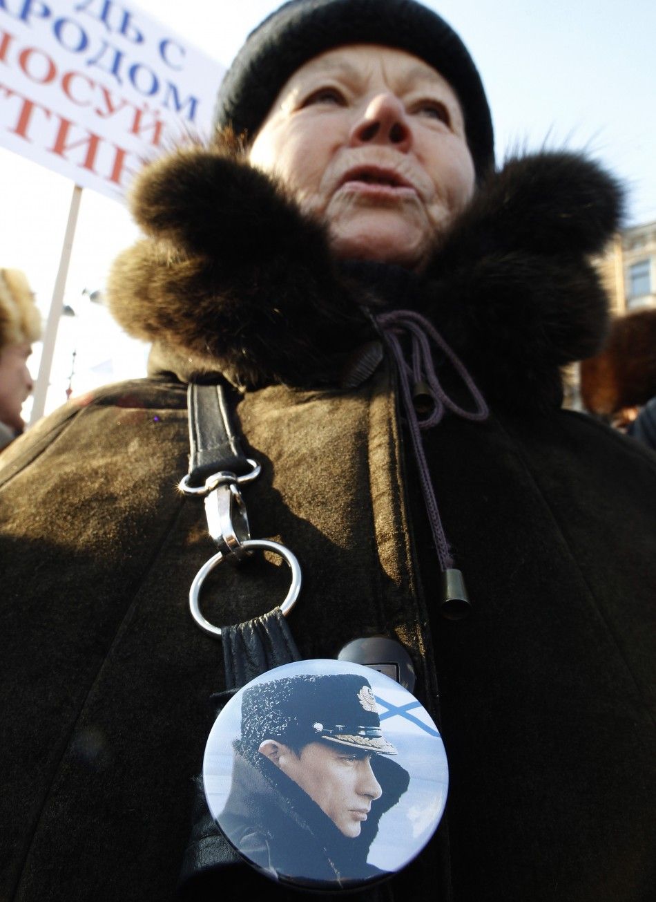 A woman wearing a badge with a portrait of Russian Prime Minister Vladimir Putin attends a rally in support of his presidential candidacy in St.Petersburg, Feb. 18, 2012.