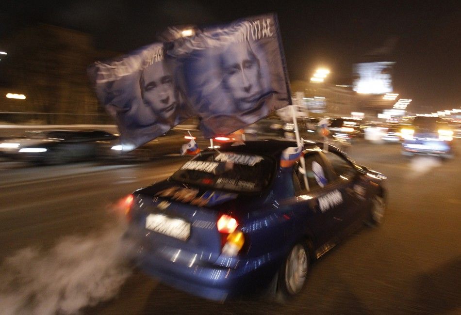 A car drives with flags showing portraits of Russian Prime Minister Vladimir Putin during a car rally to show support for Putins presidential candidacy in Moscow Feb. 18, 2012. Russia will go to the polls for a presidential election on March 4. 
