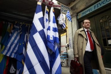 A man walks next to a kiosk selling Greek flags in Athens