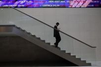 A man walks down steps under a share price ticker at the London Stock Exchange in the City of London November 1, 2011.