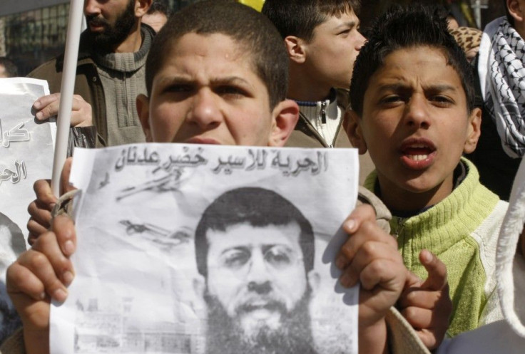 A Palestinian demonstrator holds a leaflet with an image of Islamic Jihad member Khader Adnan during a protest in his support in Nablus