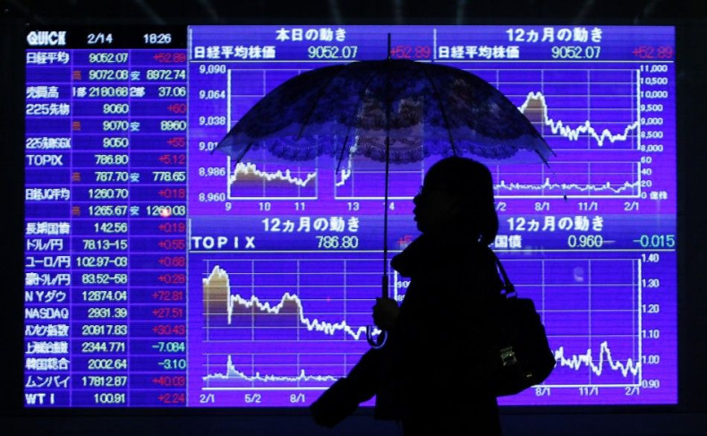 Woman walks past stock quotation board outside brokerage in Tokyo