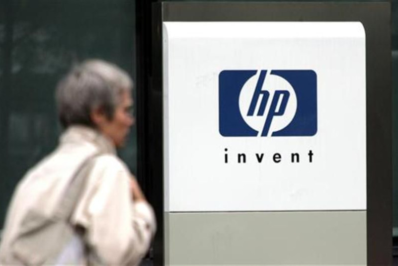 File photograph of a woman walking past the Hewlett Packard logo at its French headquarters in Issy le Moulineaux