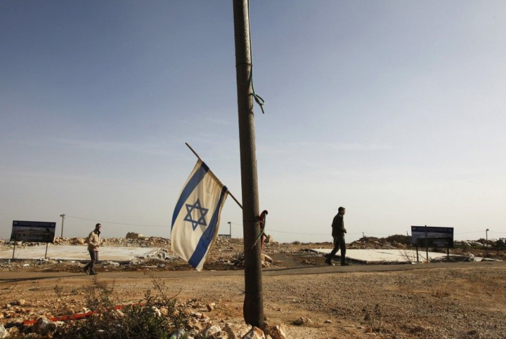 An Israeli flag hangs off a pole in front of two foundations of temporary homes demolished by the Israeli authorities last year in the unauthorised Jewish outpost of Migron, near the West Bank city of Ramallah February 8, 2012.