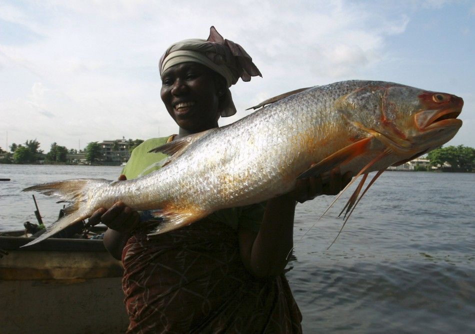 A woman carries a fish, known locally as epuya, at a fishing port in Badagry division of Lagos