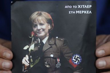 A man displays a poster depicting German Chancellor Merkel in a Nazi uniform in Athens