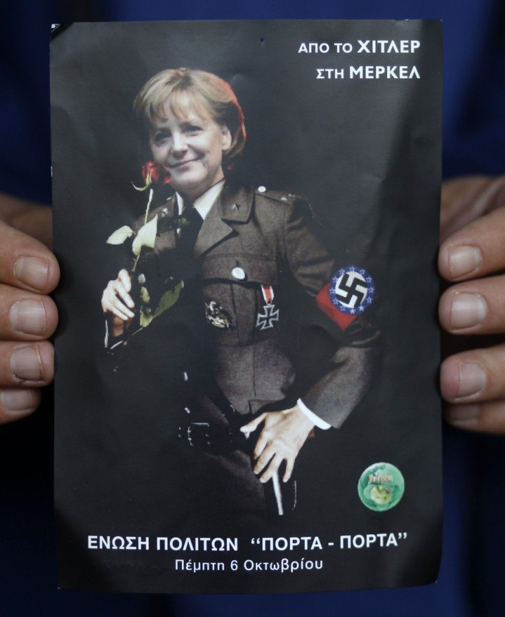 A man displays a poster depicting German Chancellor Merkel in a Nazi uniform in Athens