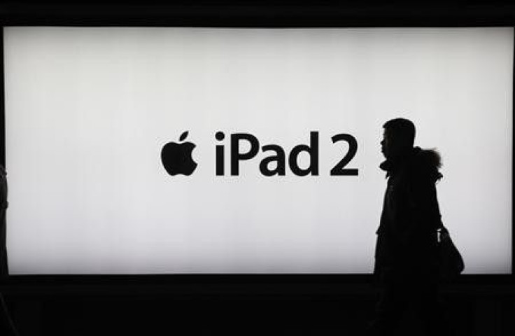 A man walks past an iPad 2 advertisement in Shanghai February 23, 2012.