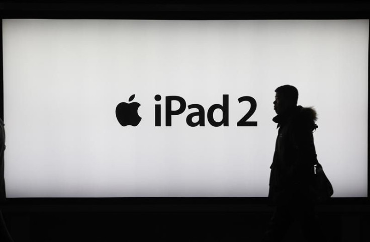 A man walks past an iPad 2 advertisement in Shanghai