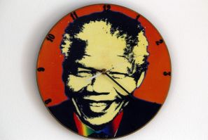 A clock made out of an old vinyl record showing Nelson Mandela's headshot is measuring time in Warsaw February 8, 2012.