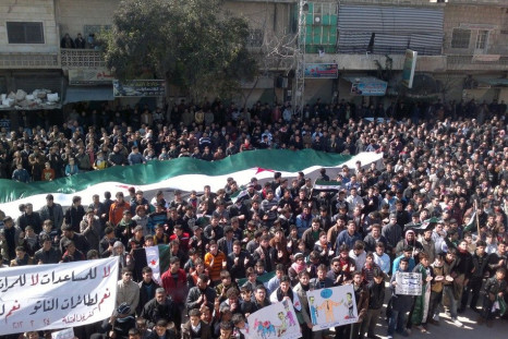 Demonstrators hold a large Syrian opposition flag during a protest against Syria's President Bashar al-Assad in Kafranbel near Idlib February 24, 2012.
