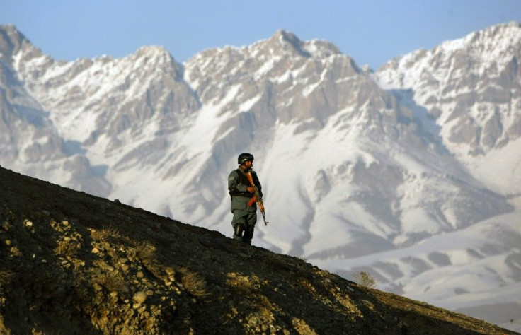 Afghan policeman keeps watch during clashes with protesters in Kabul