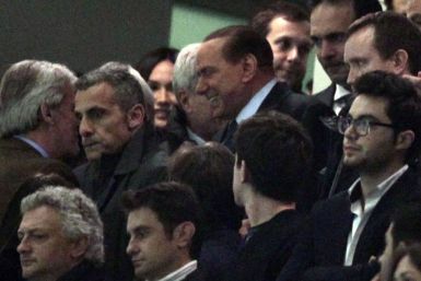 Former Italian Prime Minister Silvio Berlusconi (C) smiles as he arrives before the Italian Serie A soccer match between AC Milan and Juventus at the San Siro stadium in Milan February 25, 2012.