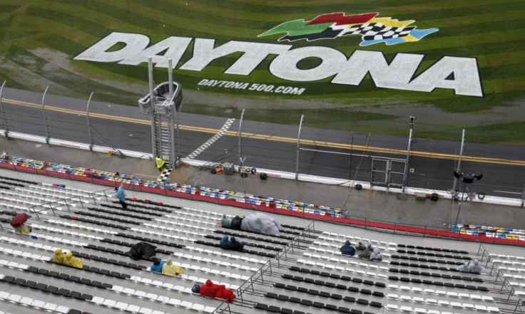 Fans sit in the rain during the delayed NASCAR Sprint Cup Series 54th Daytona 500 race at the Daytona International Speedway in Daytona Beach