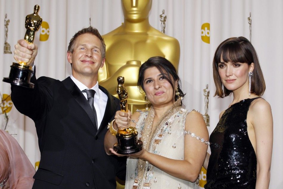Directors Daniel Junge and Sharmeen Obaid-Chinoy, winners of Best Documentary Short Subject, pose with presenter Rose Byrne backstage during the 84th Academy Awards in Hollywood