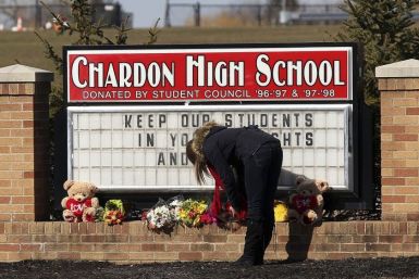 An unidentified female student places a bouquet of roses at the base of the Chardon High School sign in Chardon