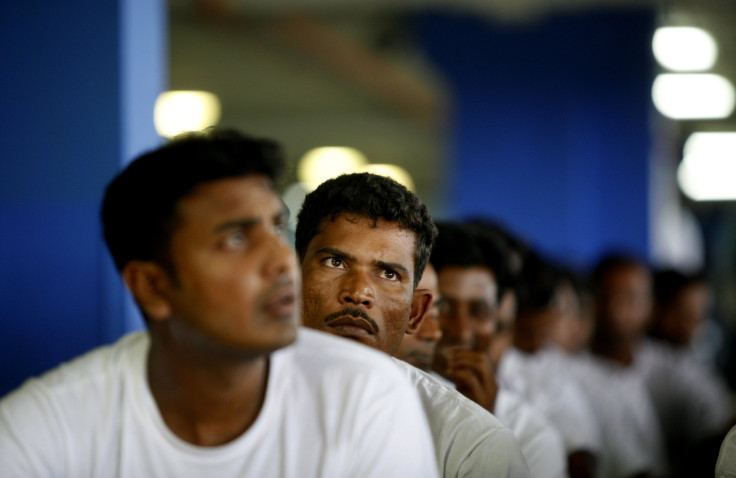 Foreign workers from Bangladesh wait at an airport carpark turned into an immigration depot in Sepang .
