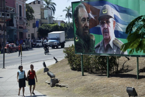 People walk beside a billboard with images of former Cuban leader Castro and his brother in Santiago de Cuba