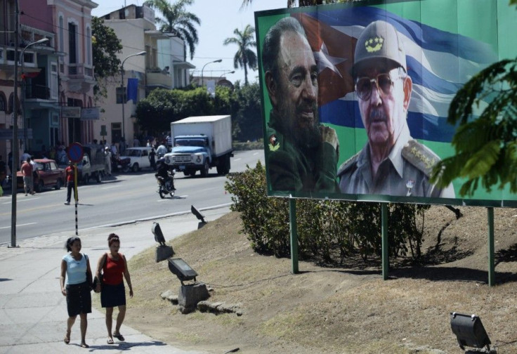 People walk beside a billboard with images of former Cuban leader Castro and his brother in Santiago de Cuba