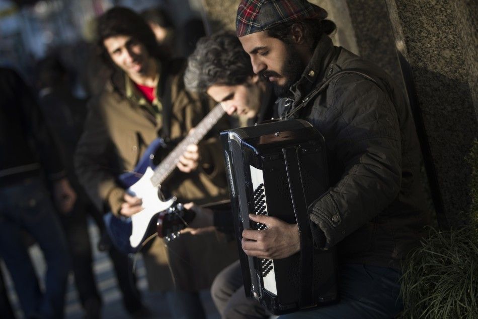 Street musicians play instruments at the side of an avenue in northern Tehran