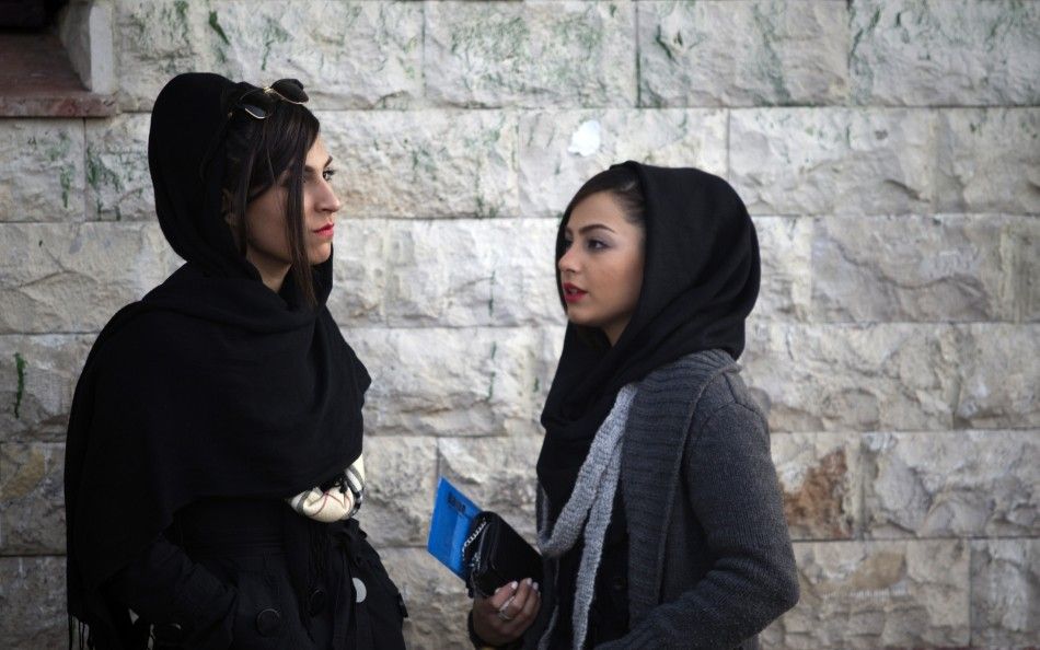 Two Iranian women talk at a corner of a square in northern Tehran