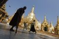 A disabled Buddhist monk walks on the grounds of Shwedagon Pagoda during the 2,600th anniversary of the pagoda in Yangon