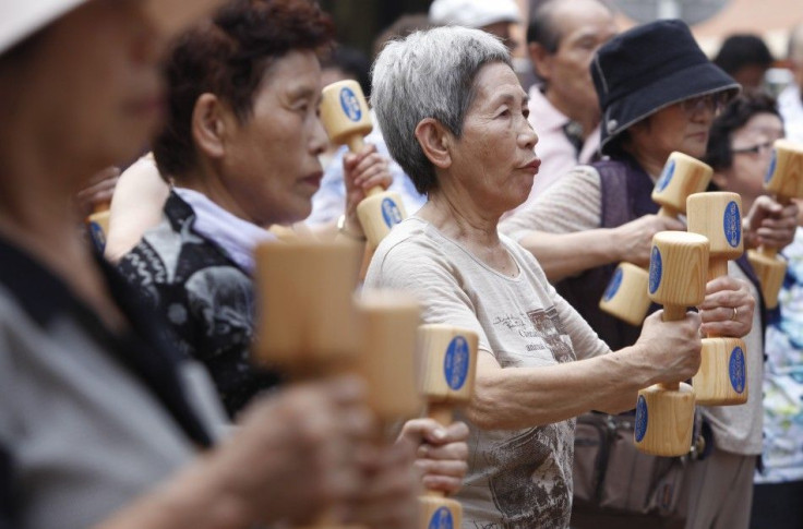 Women exercise with wooden dumbbells during a health promotion event to mark Japan&#039;s &quot;Respect for the Aged Day&quot; at a temple in Tokyo